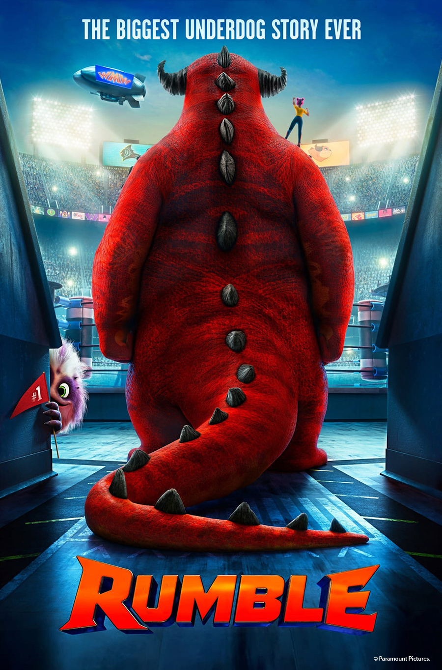 A big red, furry monster standing at a stadium entrance. Text at the top reads "the biggest underdog story ever." Text at the bottom reads "Rumble"