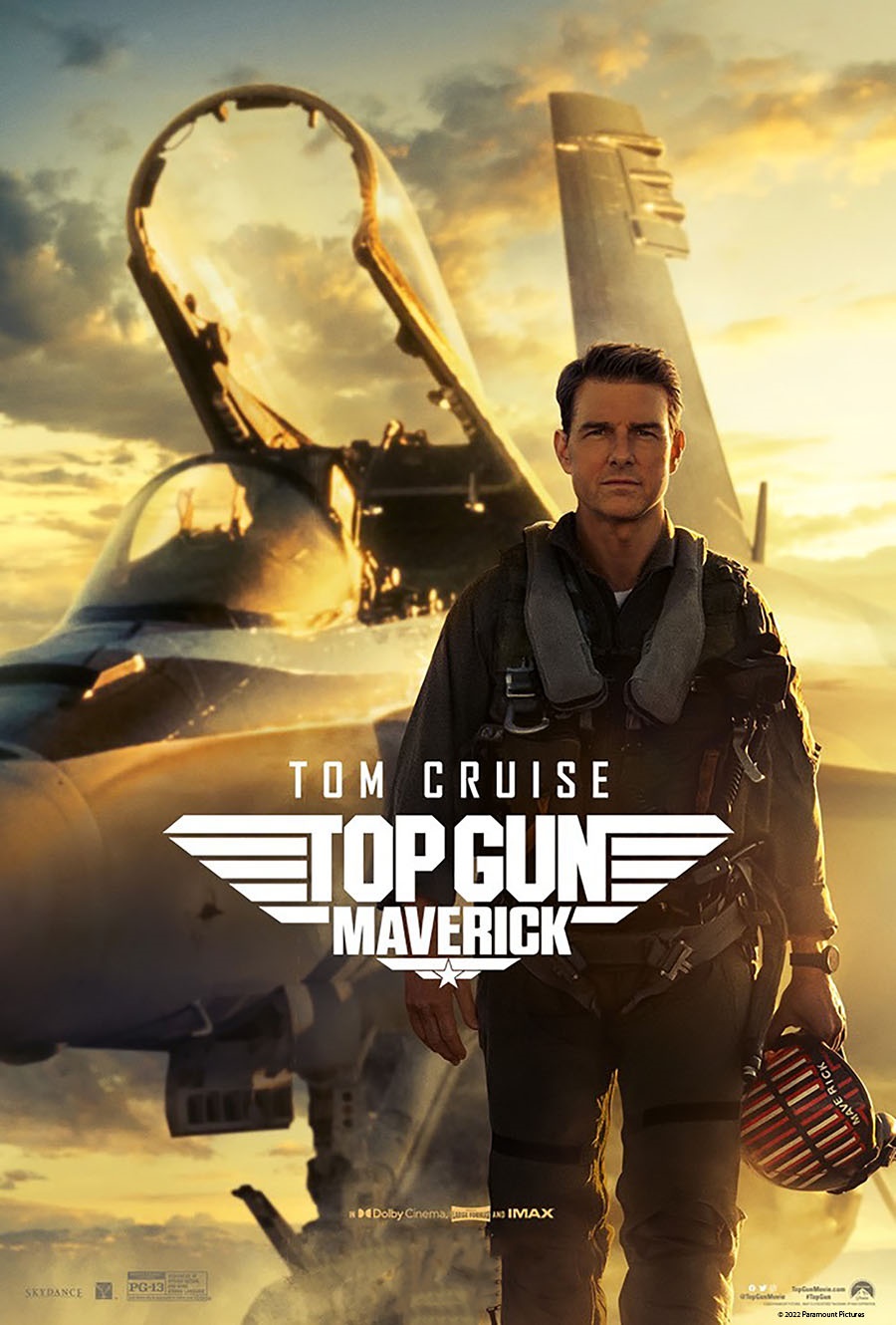 Man in flight uniform standing in front of military jet. Text says Tom Cruise Top Gun Maverick.