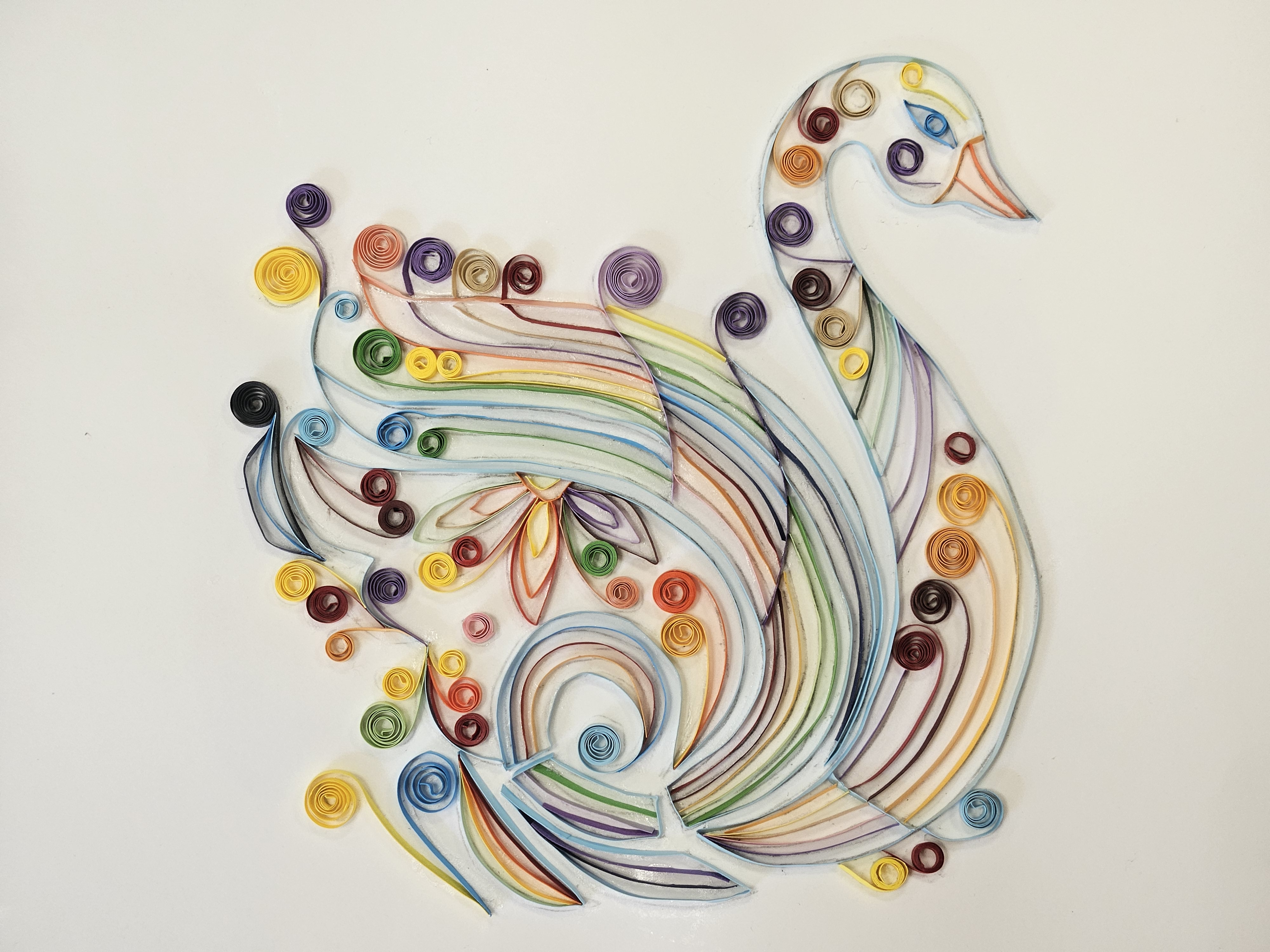 colorful swan on paper made from quilling (rolling strips of paper)