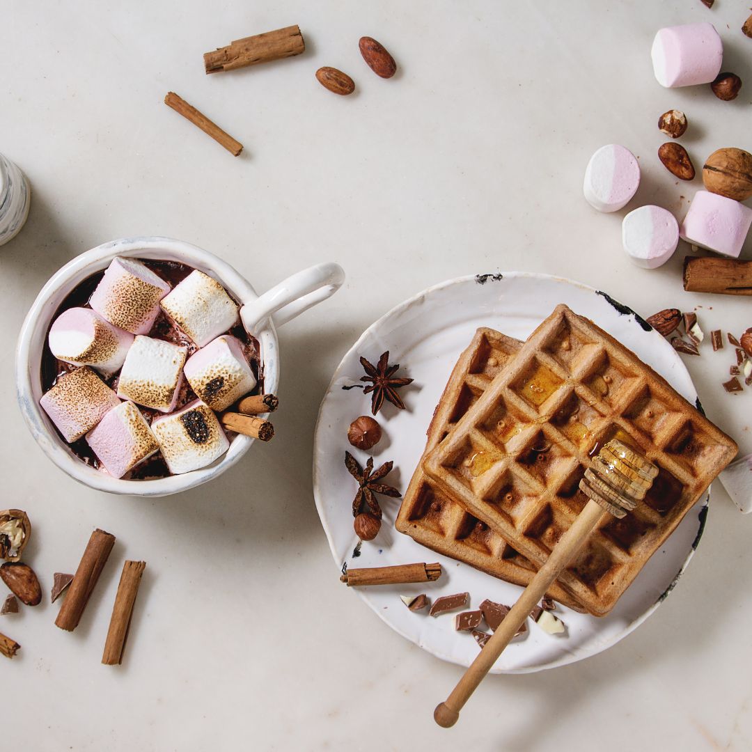 hot chocolate with marshmallows and waffles on a plate