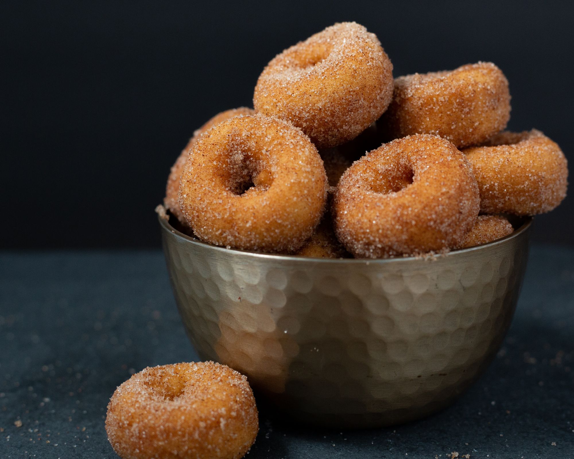 mini cinnamon sugar donuts in stainless steel bowl