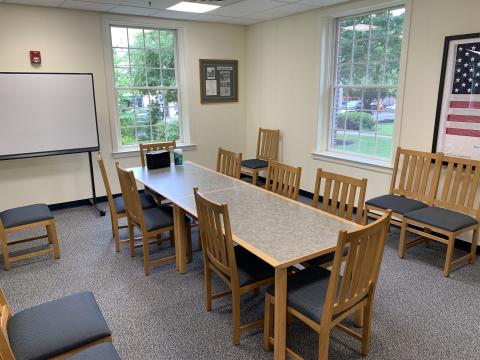 Meeting room with tables and chairs. White board in background.