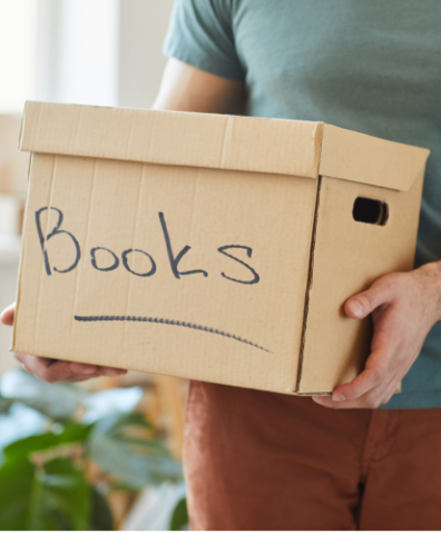 Person holding a cardboard box labeled "Books"