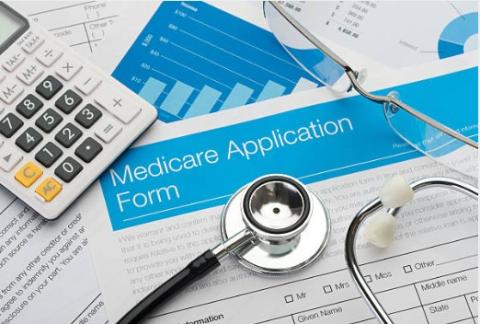 Medicare application form, a calculator, and a stethescope
