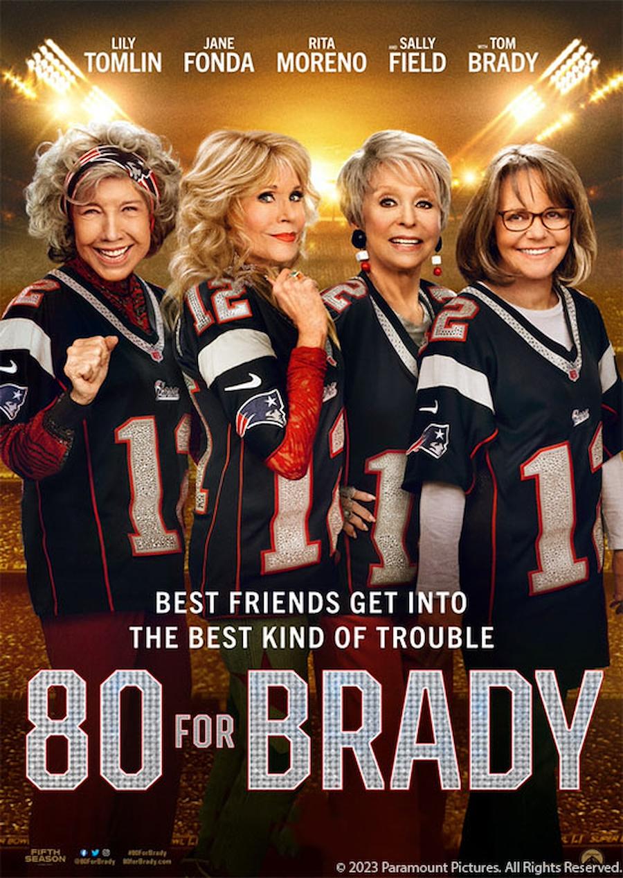 4 older women wearing football jerseys and smiling