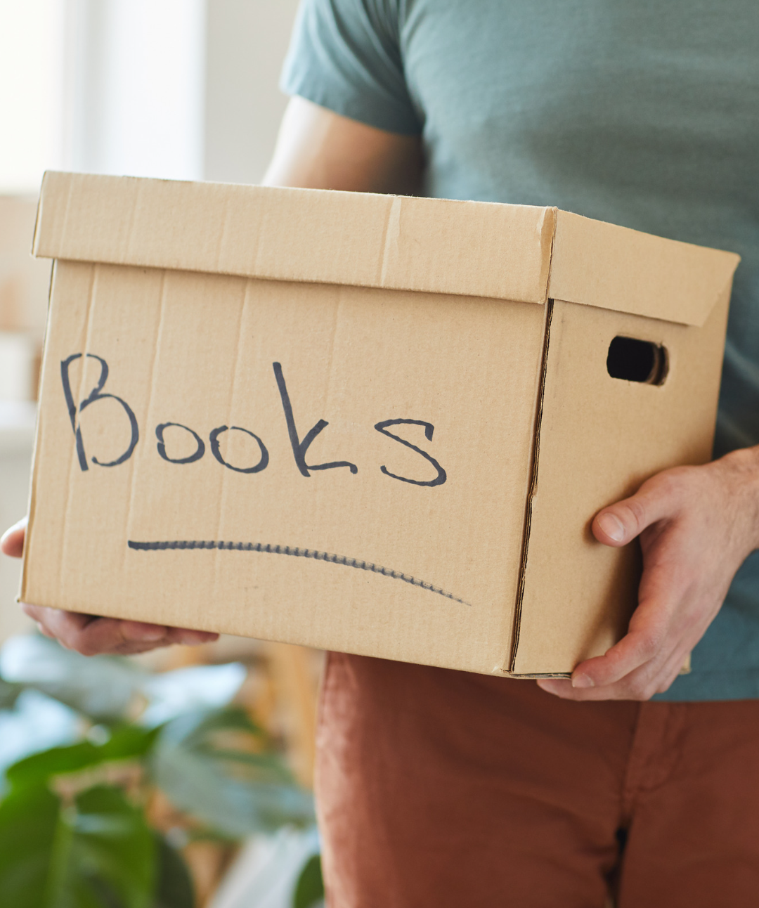 man holding a box of books